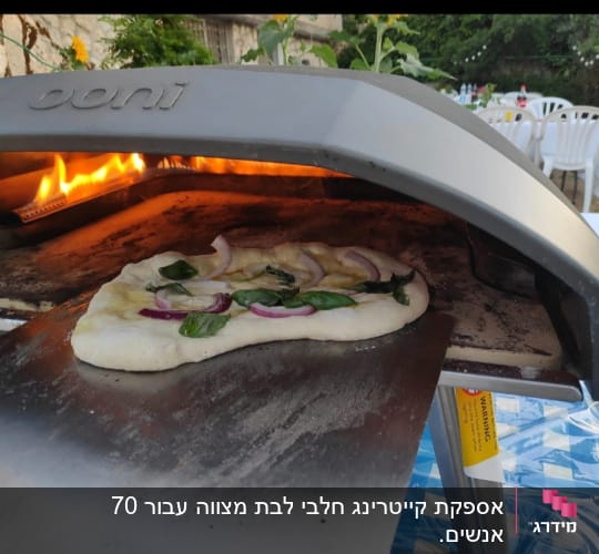 פיצה בתנור אבן עם להבות, על שולחן קייטרינג